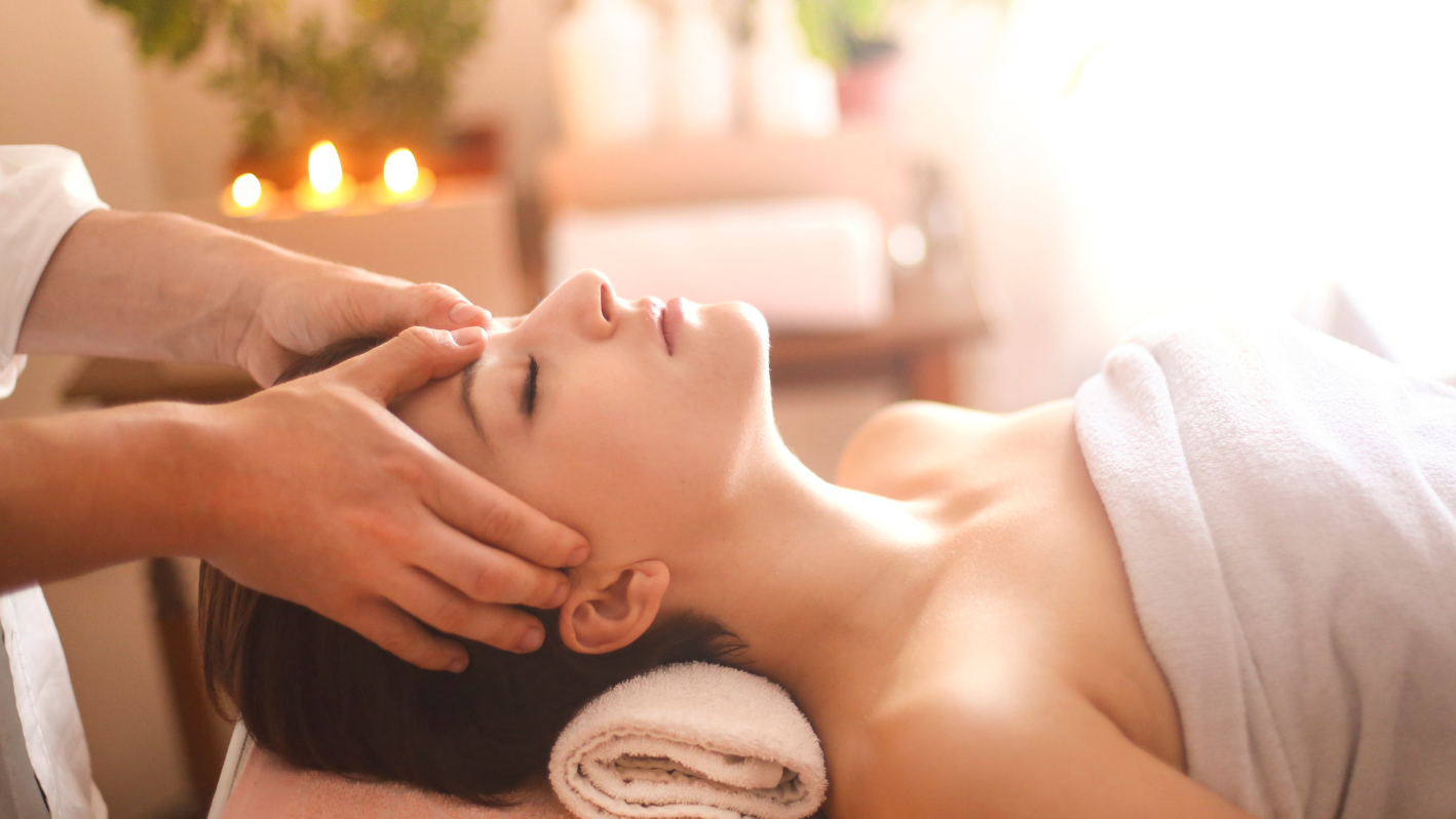 A woman getting a facial massage at a spa