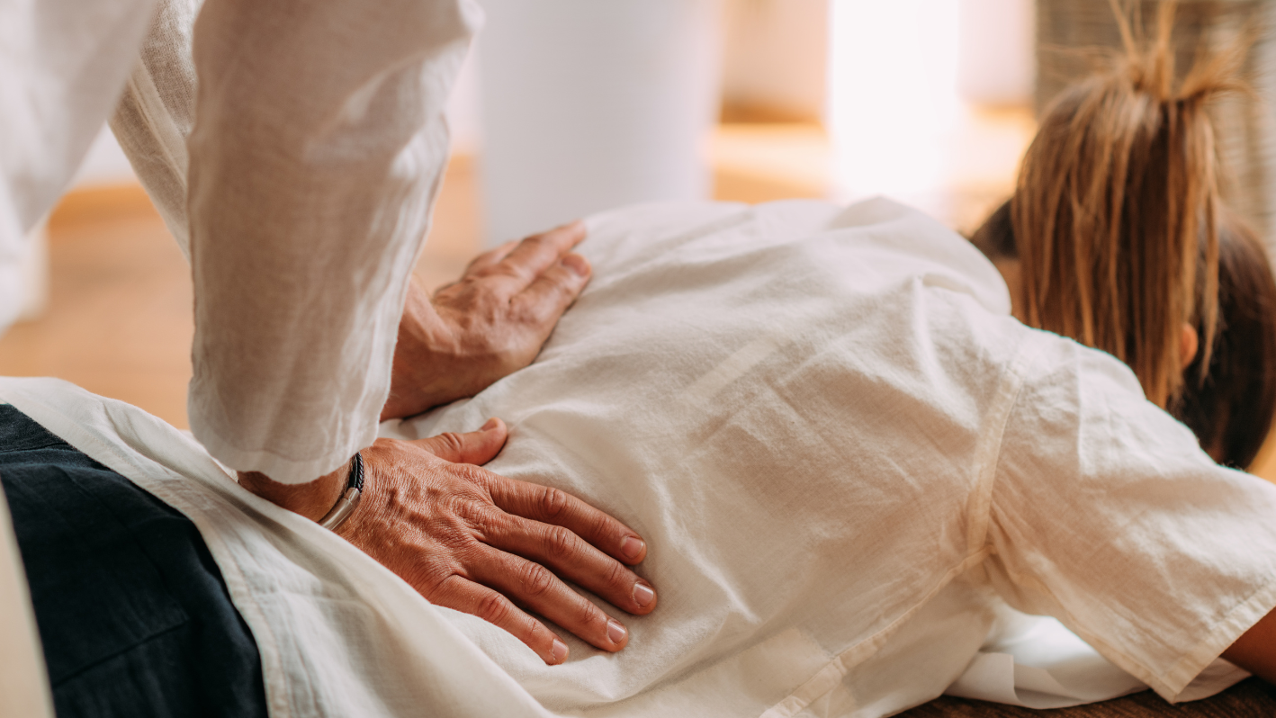 A woman laying on the floor with her hands on a man's back